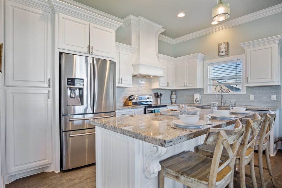 Pineapple Paradise Kitchen: Entertain guests in style in this luxurious kitchen, featuring a granite island with bar seating, perfect for serving hors d'oeuvres and cocktails while enjoying the coastal breeze.