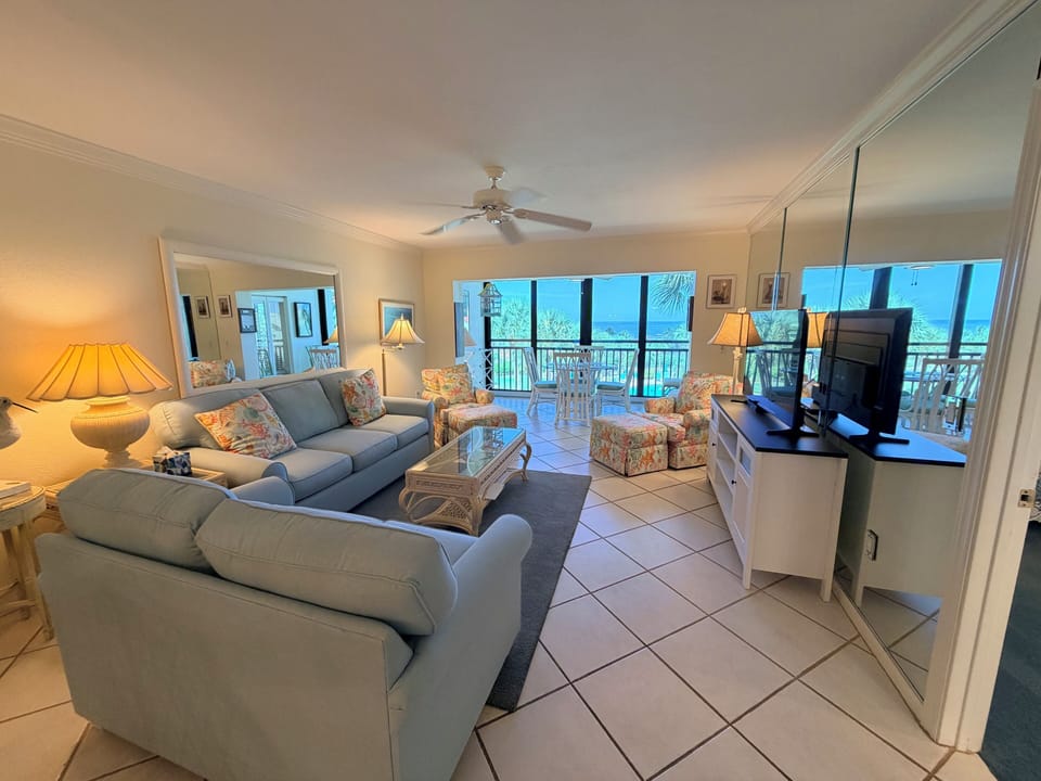 Unwind in your bright, beachy living space, where plush seating and coastal charm invite you to relax while soaking in stunning ocean views from your private balcony.