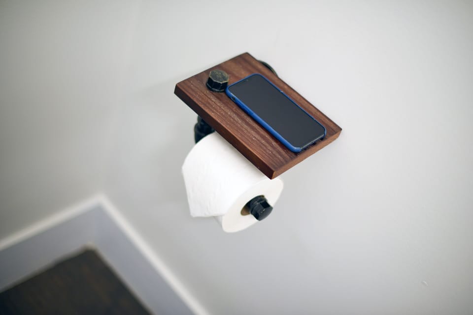 Convenient toilet paper holder with shelf for your phone or essentials.
