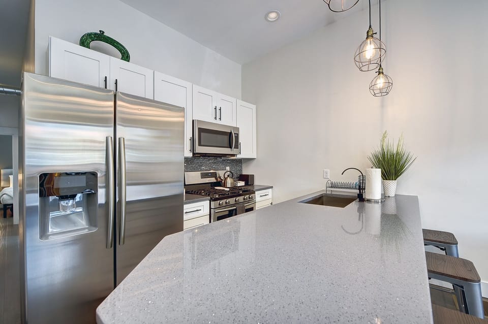 Fully equipped kitchen w/ appliances, pendant lights, coffee & utensils.