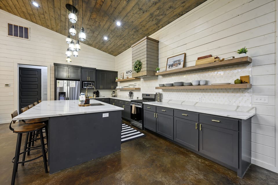 Kitchen complete with refrigerator, oven, gas stovetop, microwave, dishwasher, Keurig coffee maker, and KitchenAide mixer.