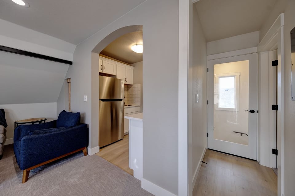Showing hallway to the bedroom on the right. Door to the stairs straight ahead.