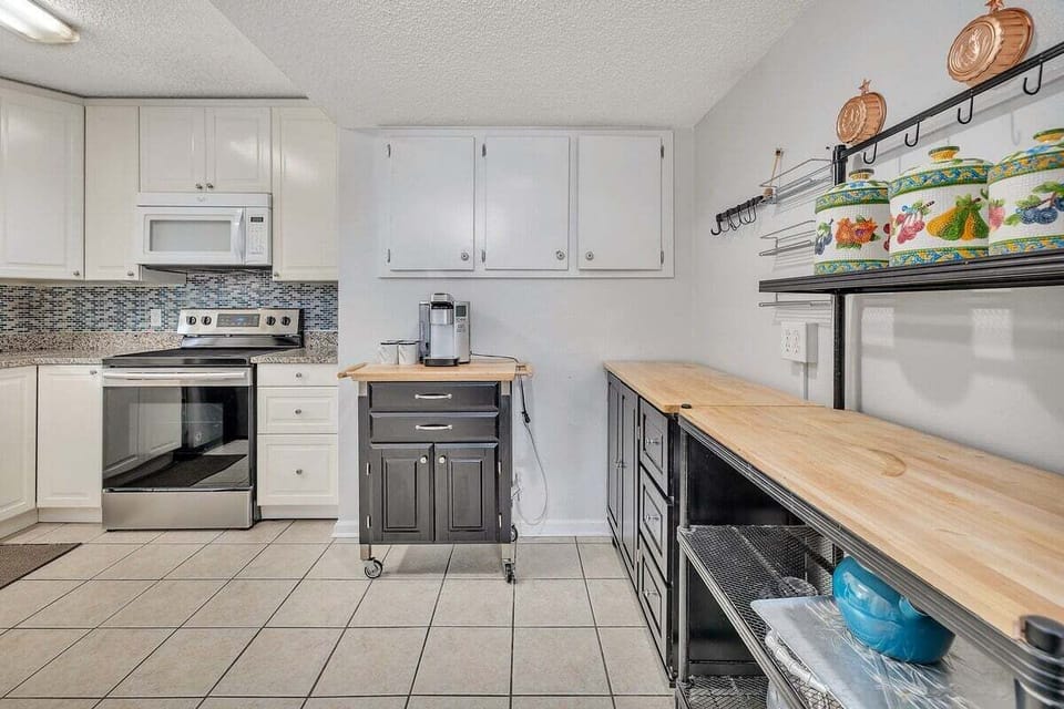 White kitchen with butcher block island and tile floors