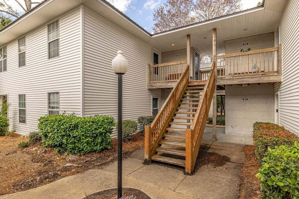 Property exterior with staircase and upper deck