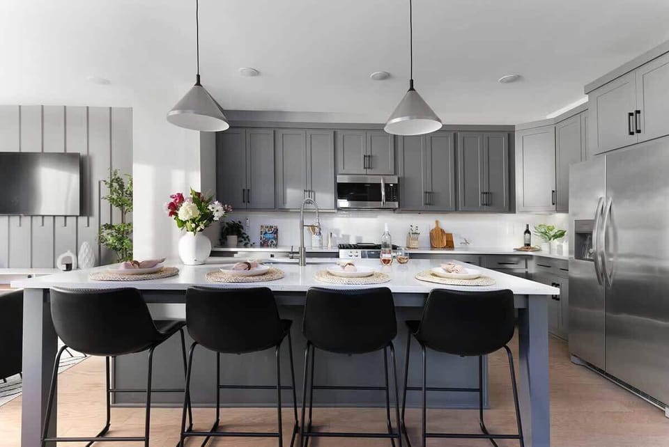 The oversized kitchen island provides ample countertop space for cooking and includes four barstool seats for added convenience.