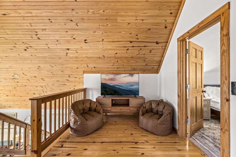 55 inch Roku TV in loft area with bean bag chairs.  Children's books in drawers.