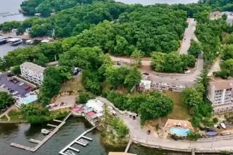 Resort-style lake getaway surrounded by lush woods, featuring marina access, pool, walkable lake bars, and prime location for boating, dining, and nightlife.