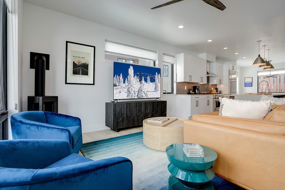 Sink into luxury in your open-plan living space, where modern elegance meets cozy comfort with plush seating and a fully equipped kitchen.