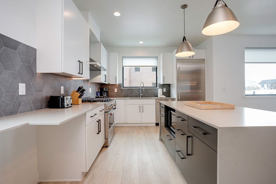 Cook in this sleek modern kitchen featuring stainless steel appliances, quartz countertops, and stylish pendant lighting for your culinary adventures.