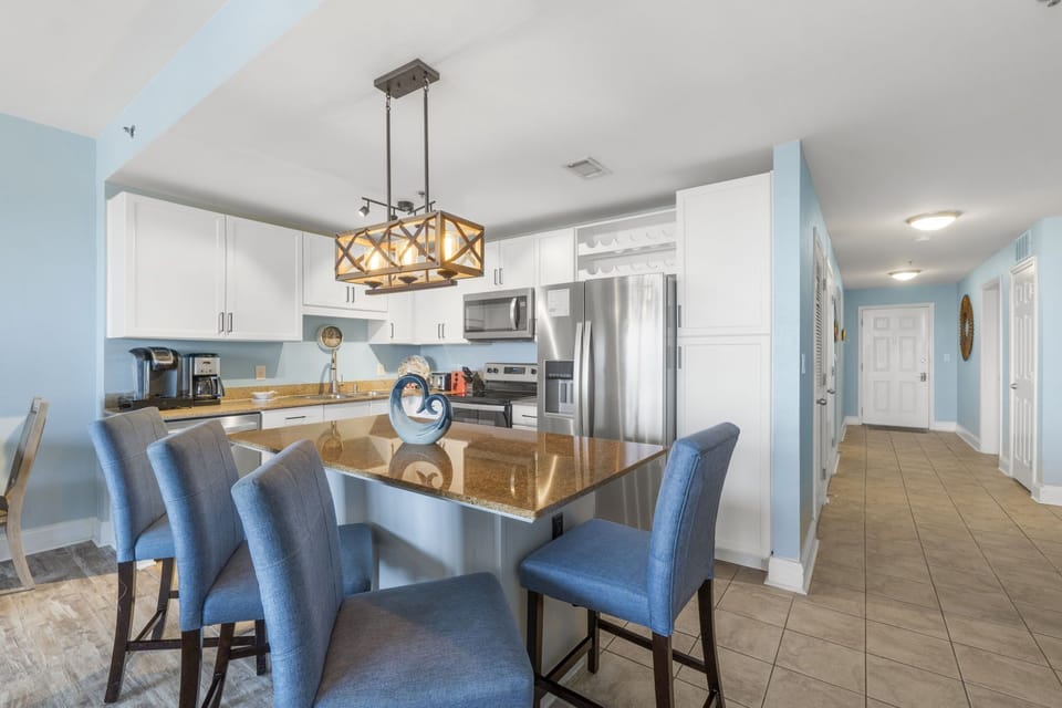 Modern kitchen with stainless steel appliances and a spacious island with seating.