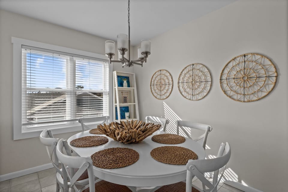 Gather around your bright dining table for memorable meals, with coastal charm and natural light streaming through the windows.