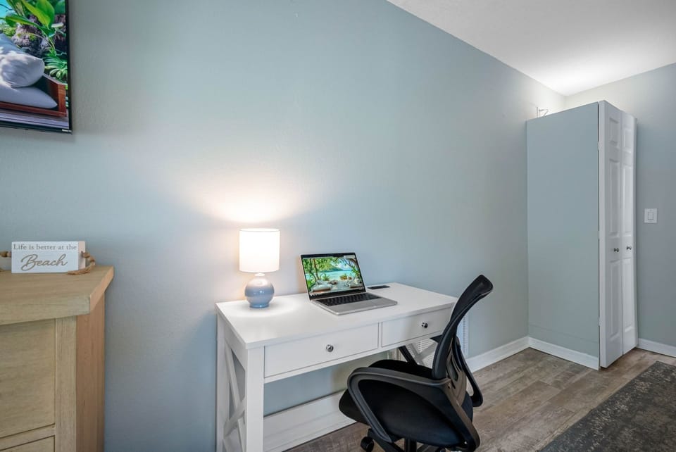 Bright and airy king bedroom featuring a sleek ceiling fan, work desk, and ensuite access — the perfect space to recharge.