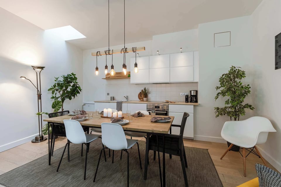 Dining corner with modern lights and lush green touches.

