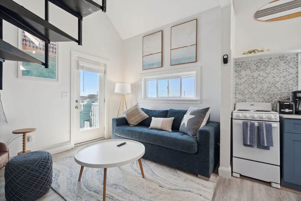 Living room with comfy couch, smart TV, and access to the private balcony