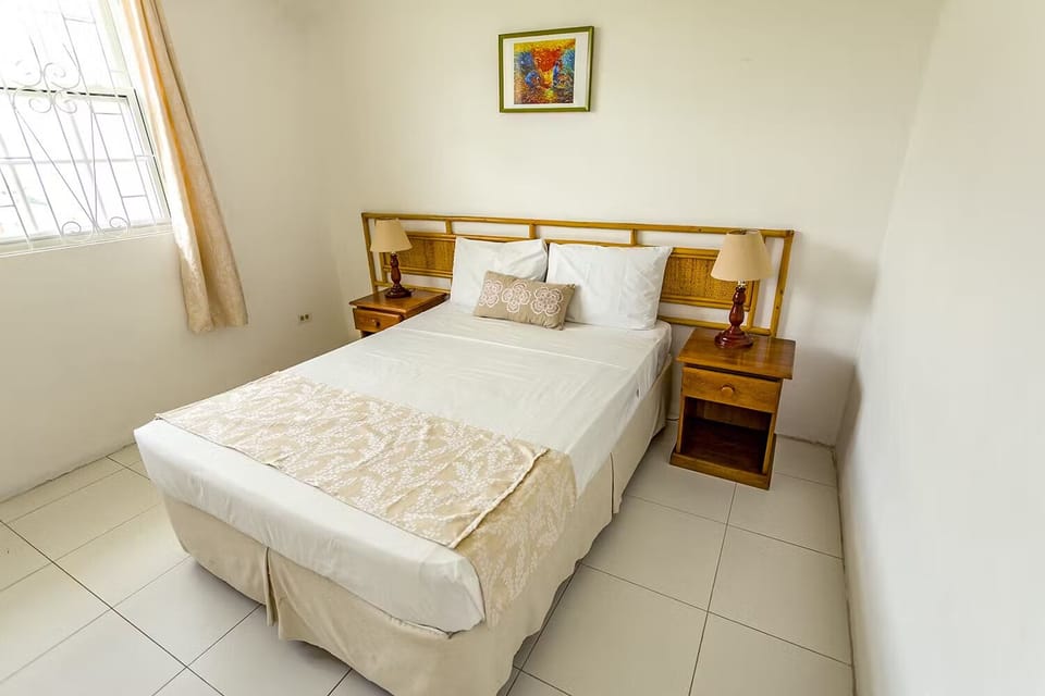 Unwind in a serene queen bed with cozy bedside lighting.