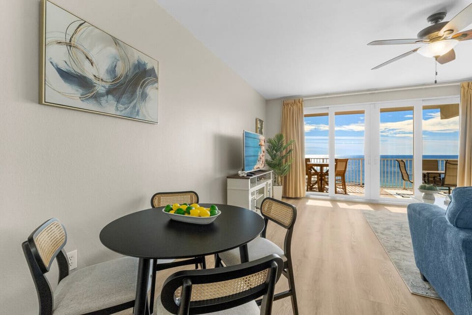Charming dining nook with stylish seating, adjacent to a cozy living area and balcony with stunning ocean views