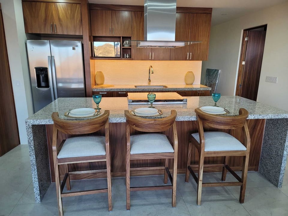 Step into the beautiful kitchen, equipped with modern appliances and ample counter space. Perfect for culinary enthusiasts, this kitchen boasts sleek finishes, a large refrigerator, and bar seating for casual dining. Whether you're preparing a gourmet meal or a quick snack, you'll find everything you need to make your stay enjoyable. The adjacent sitting area is ideal for morni...