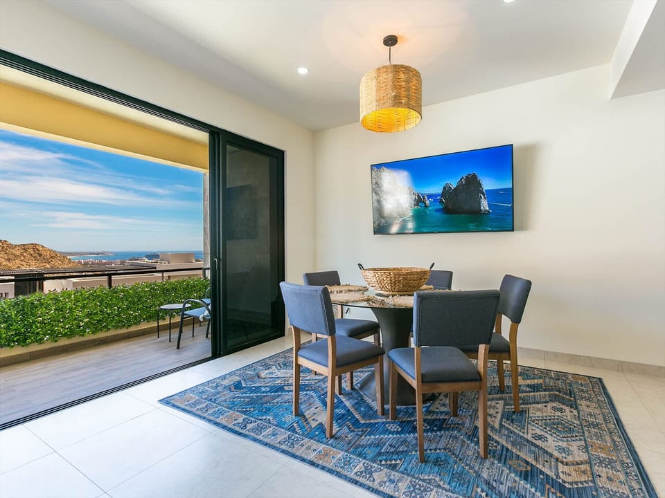 The dining room opens up to a large balcony, where spectacular views await. This seamless connection enhances your dining experience, allowing you to enjoy beautiful vistas while you eat. The expansive balcony provides a perfect setting for meals with a view, blending indoor comfort with outdoor beauty.