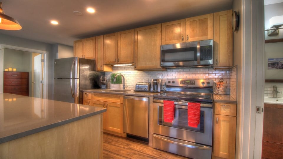 Experience the modern, fully-equipped kitchen boasting high-quality stainless steel appliances.