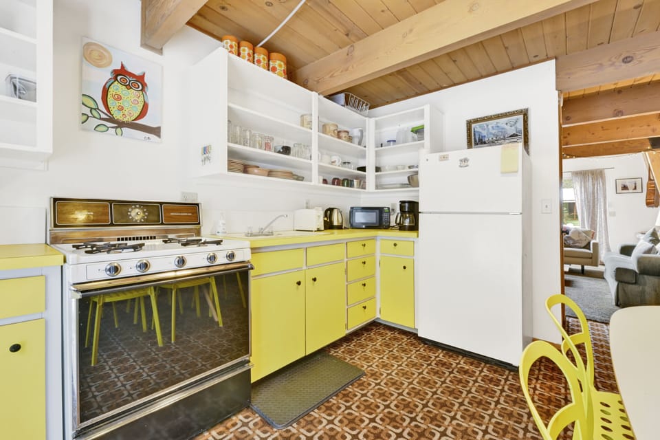 Fully equipped cabin kitchen with ample cabinetry, stove, fridge, microwave, and coffee maker—perfect for cooking meals, morning coffee, and feeling right at home on your stay.