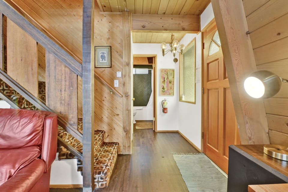 Cozy mountain living room with a stone fireplace, comfy seating, and smart TV—perfect for relaxing evenings, movie nights, and warm cabin vibes after outdoor adventures.