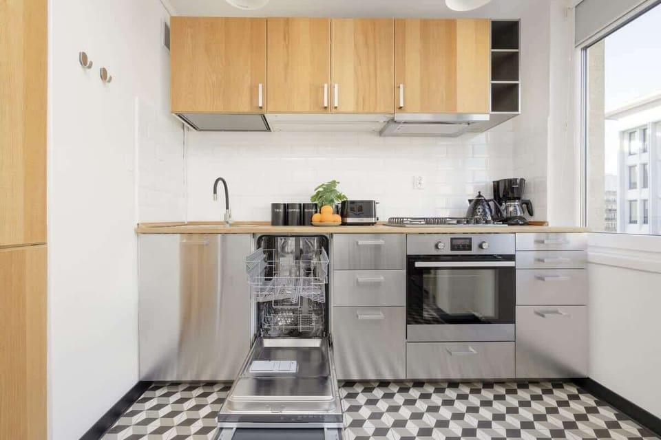 Another view of the kitchen, featuring a built-in oven, a gas stove, and overhead cabinets providing ample storage.

