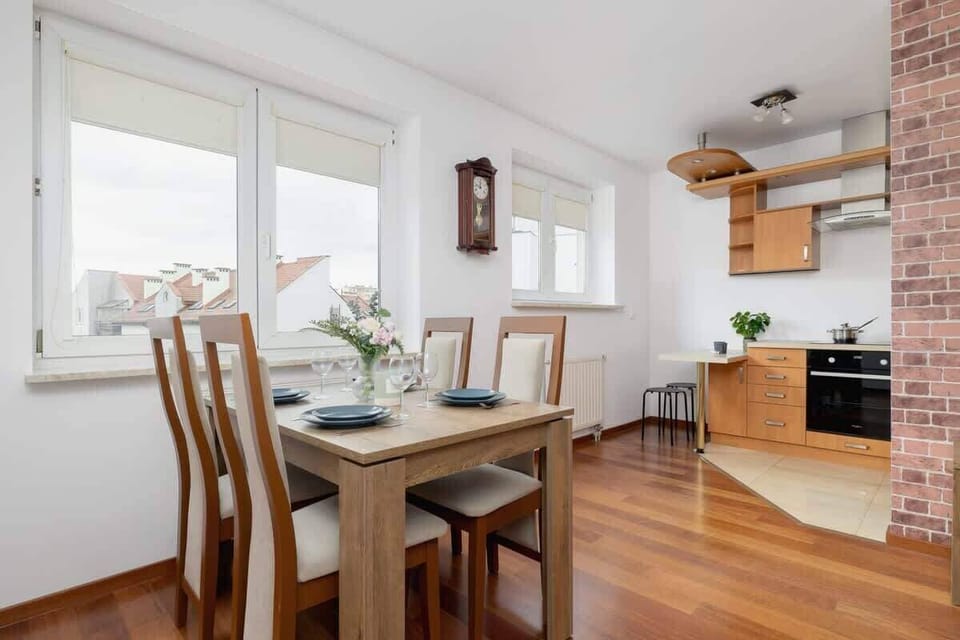 Another view of the kitchen and dining space, emphasizing the open layout, large windows, and natural wood tones for warmth.

