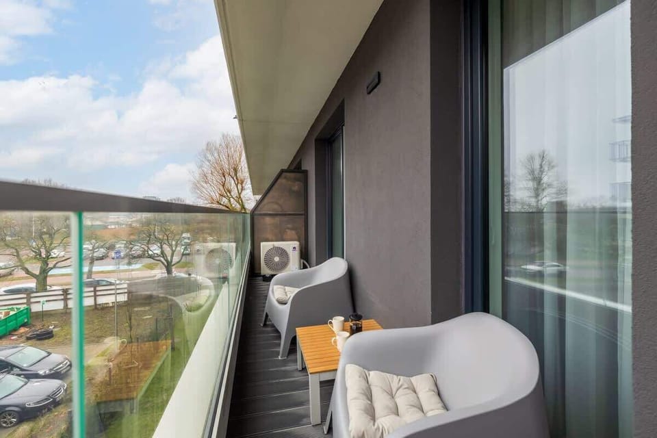 A cozy balcony with a small seating area, offering a perfect spot to relax and enjoy the outdoor view.

