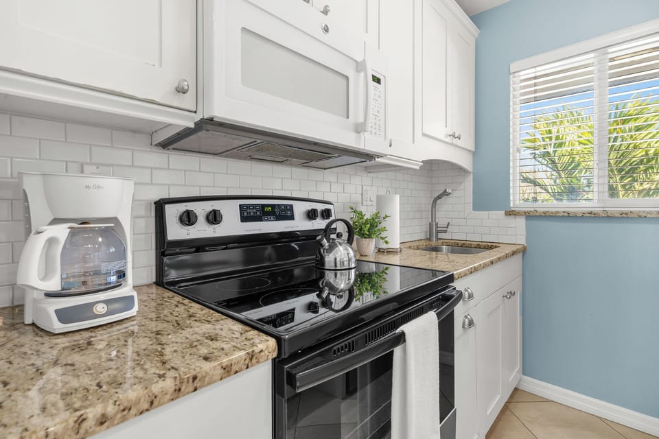 Your fully equipped kitchen features granite counters, stainless appliances, and a tropical garden view to inspire your culinary adventures.