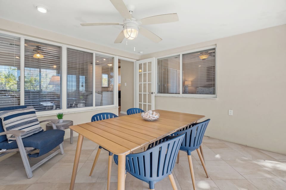 Your dining area features coastal-inspired blue chairs and warm wood table, perfect for morning coffee or evening meals together.