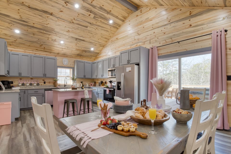 Bright dining area with pink accents, wooded views, and easy flow into the kitchen.