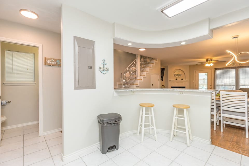 Gather around your breakfast bar with coastal charm, where beach-themed decor and an open layout create the perfect space for morning coffee and conversation.