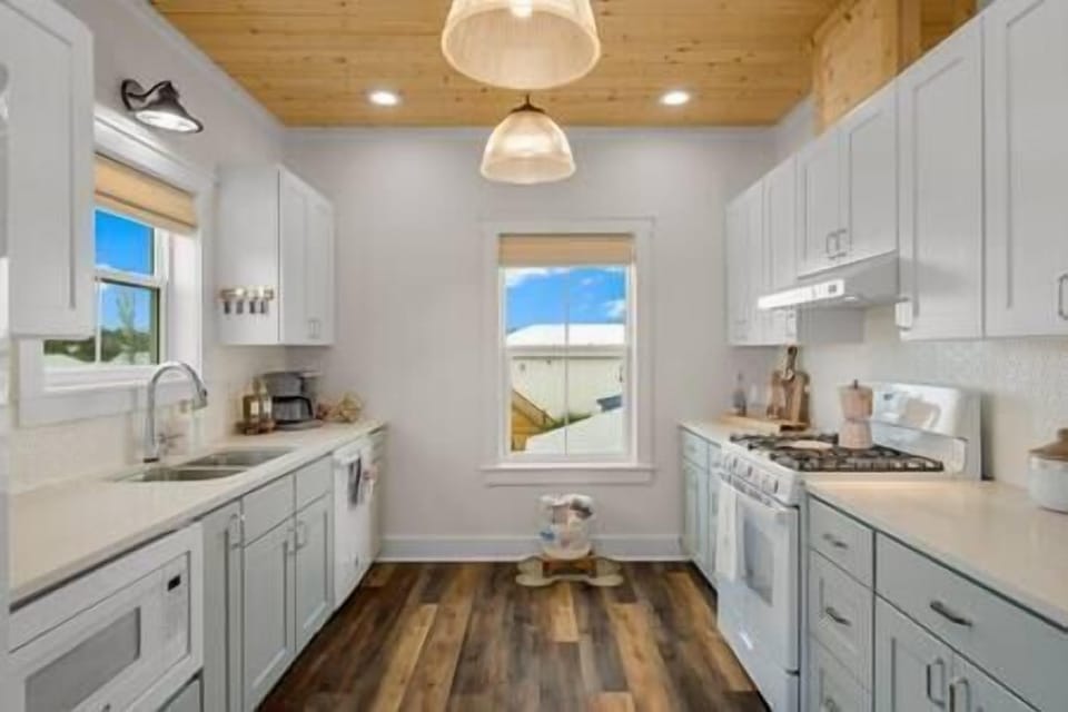 Wood, Tongue in Groove Ceilings adorn the Kitchen Ceiling with Glass Pendants.