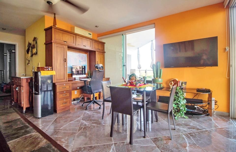 Common area with built in desk, dining table, tv, futon