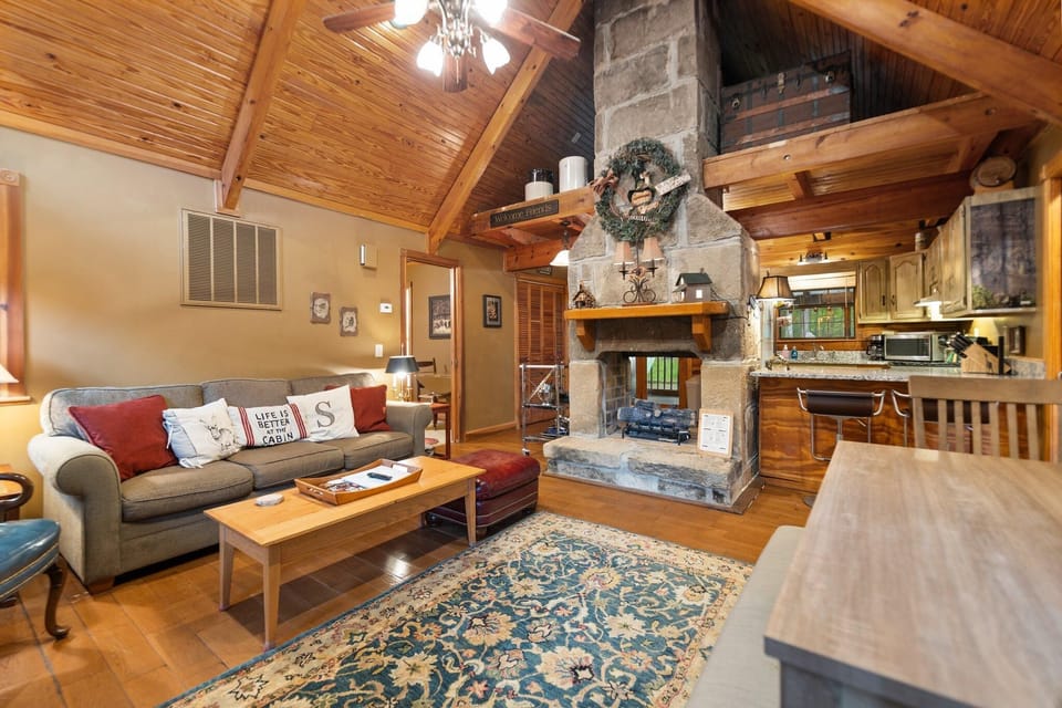Cozy living room with vaulted ceilings and stone fireplace
