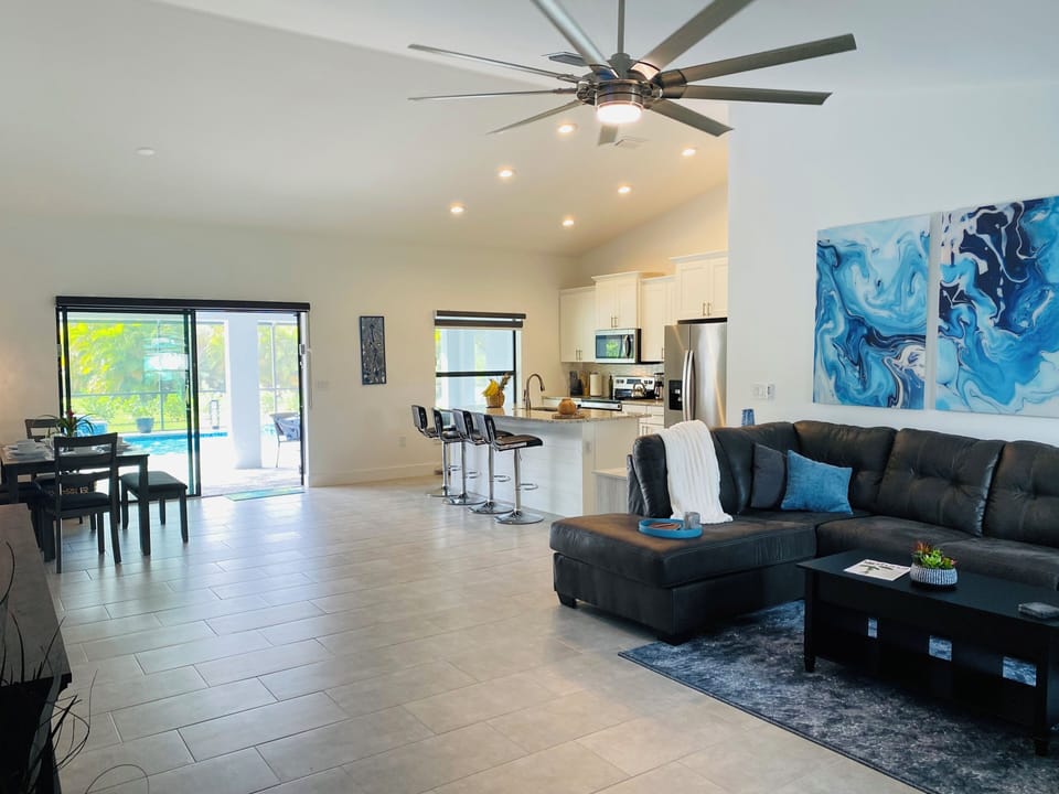 Living area with large comfy couch & recliner and pool views
