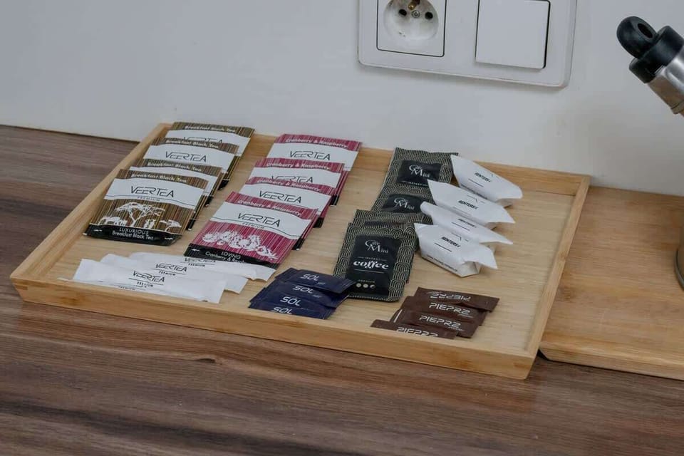 A wooden tray displaying neatly stacked and colorful tea and coffee, adding a gourmet touch to the space.

