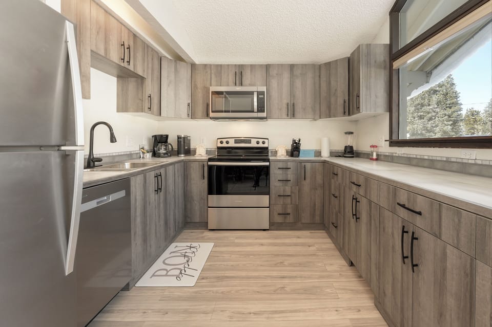 Your modern kitchen offers everything you need with stainless steel appliances, generous counter space, and warm wood-grain cabinetry for memorable meals.