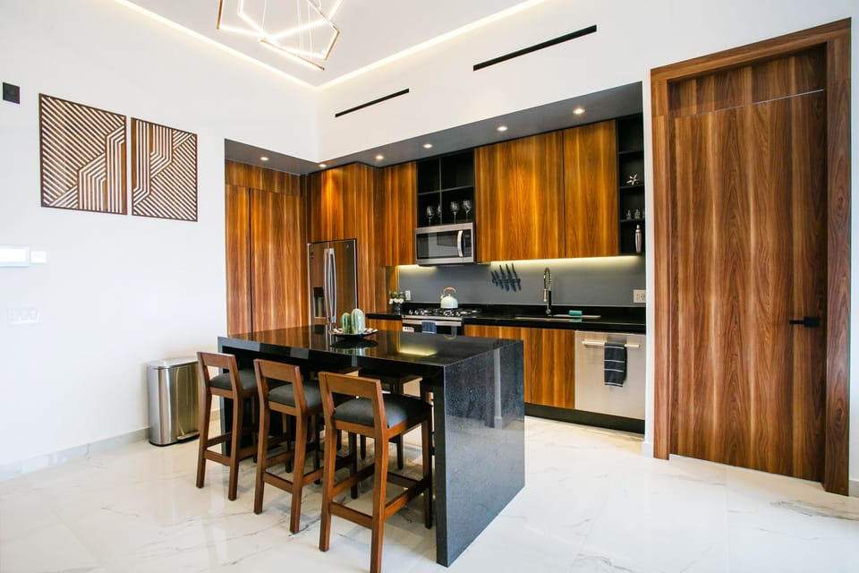 The elegant kitchen is outfitted with a comprehensive array of utensils, ensuring every culinary need is met