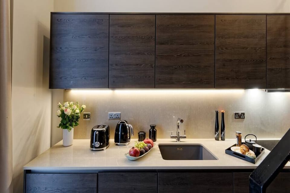 Open space with private kitchen area fully equipped with washing machine-dryer, oven-microwave, stove, kettle, toaster, Nespresso coffee machine, and kitchenware. Salt and pepper included. Non-included oils or food.
