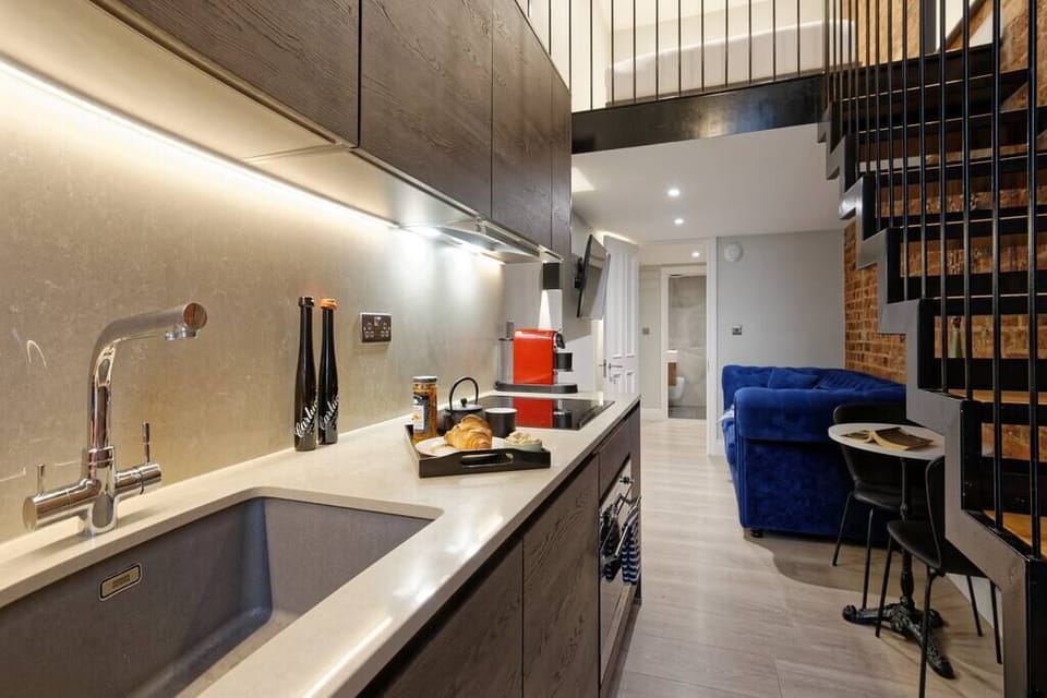 Open space with private kitchen area fully equipped with washing machine-dryer, oven-microwave, stove, kettle, toaster, Nespresso coffee machine, and kitchenware. Salt and pepper included. Non-included oils or food.