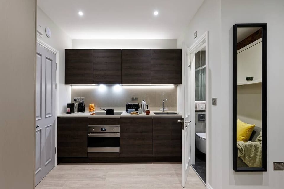 Kitchen fully equipped with oven-microwave, stove, mini fridge, washing machine/dryer, coffee machine, kettle, toaster and kitchenware.