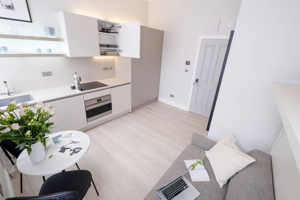 Open space with private kitchen area fully equipped with washing machine-dryer, oven-microwave, stove, kettle, toaster, Nespresso coffee machine, and kitchenware. Salt and pepper included. Non-included oils or food.
