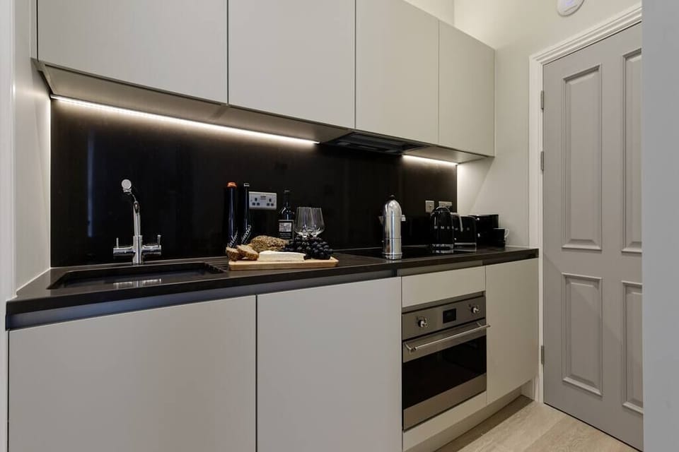 Open space with private kitchen area fully equipped with washing machine-dryer, oven-microwave, stove, kettle, toaster, Nespresso coffee machine, and kitchenware. Salt and pepper included. Non-included oils or food.