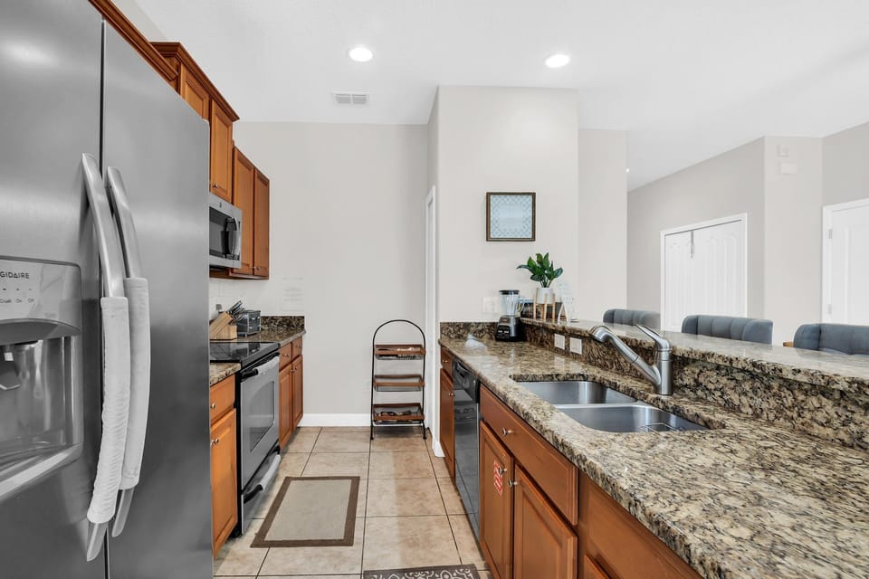 A stainless steel refrigerator and spacious kitchen layout with generous countertop space.