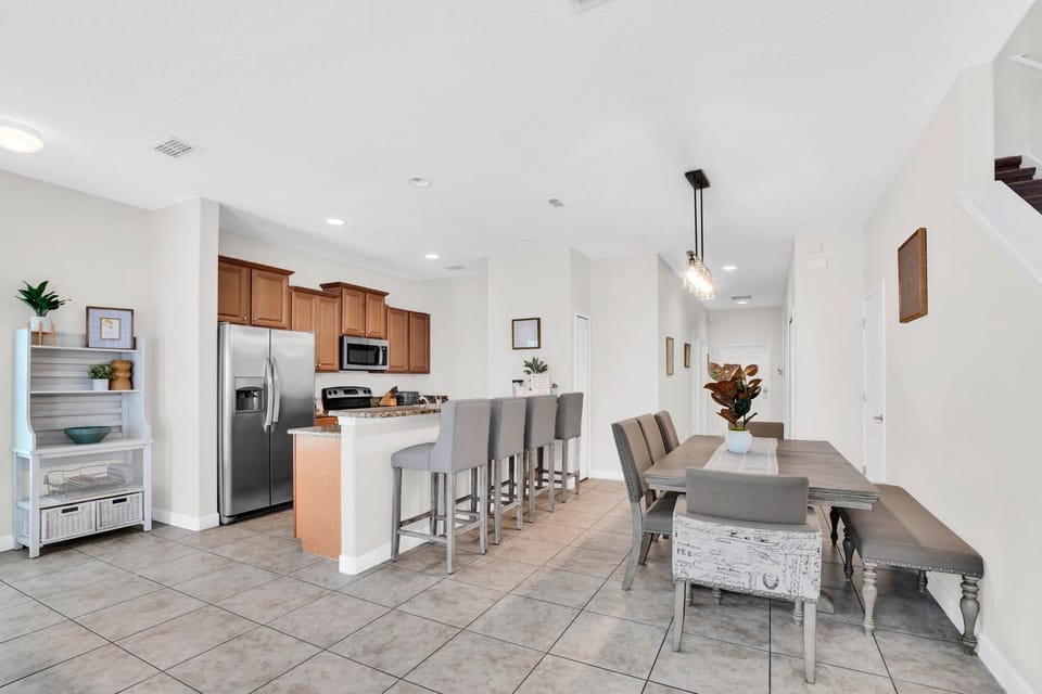 A bright kitchen with stainless steel appliances, granite countertops, and a breakfast bar.