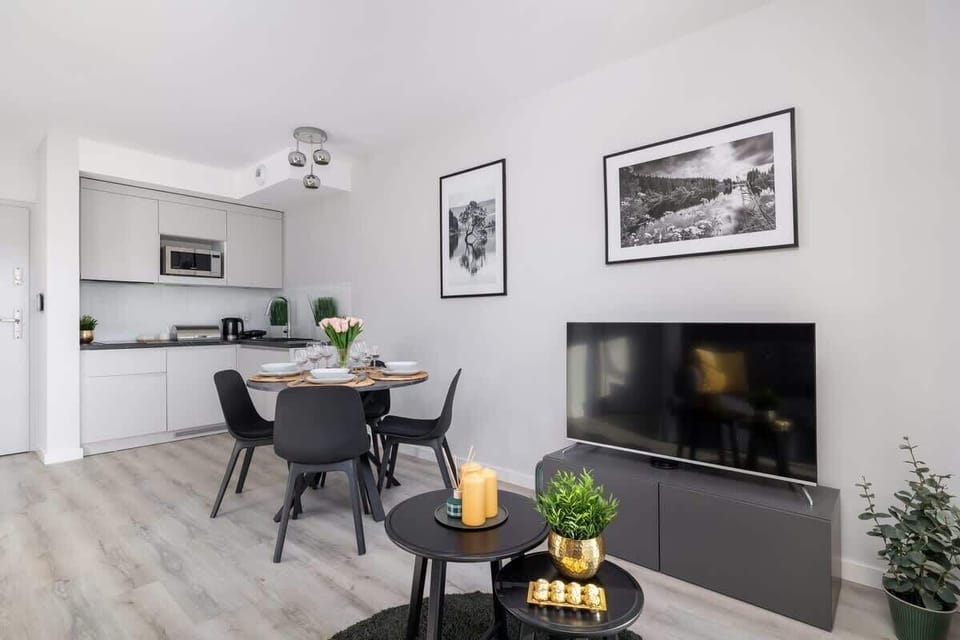 Another shot of the open-plan living and dining area, showcasing the mounted TV, stylish decor, and a comfortable modern design.







