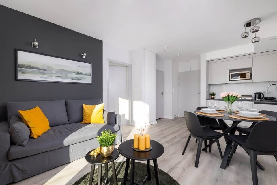 Another angle of the living and dining area, highlighting the stylish decor, a dark feature wall, and a cozy, inviting ambiance.

