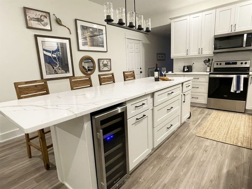 Beautifully appointed kitchen featuring quartz countertops, large center island, bar seating, and stainless steel appliances.