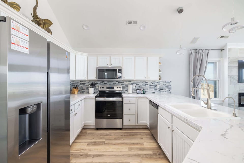 Top Level: Bright, Fully Stocked Kitchen with Breakfast Bar Seating